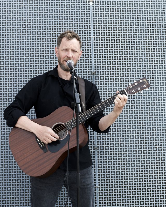 Jesper synger og spiller guitar ved mikrofonen